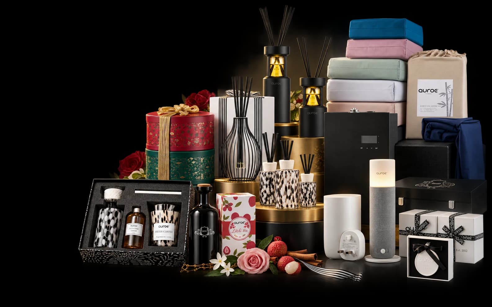 Auroe reed diffusers, candles, gift sets and linens arranged on a dark stage